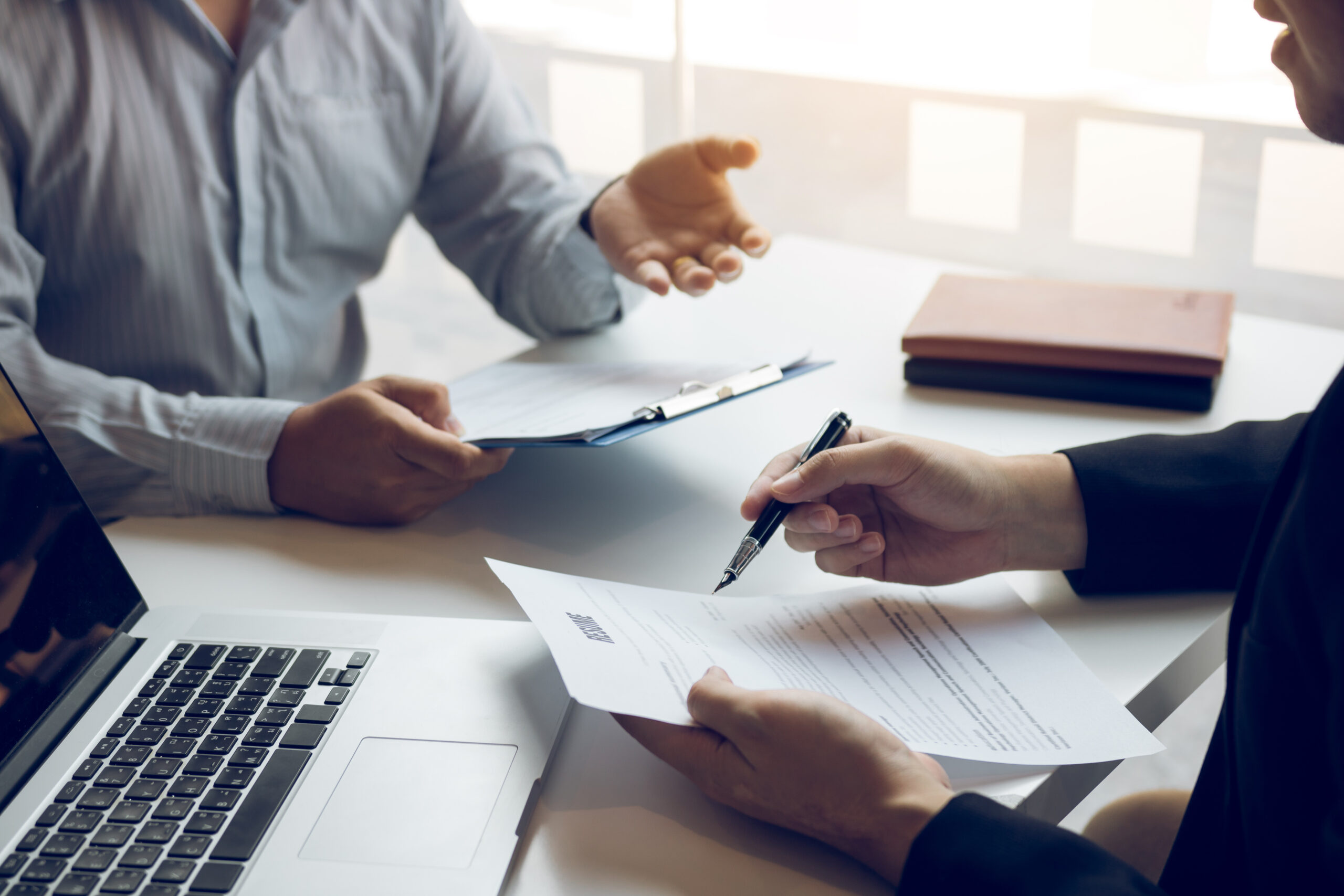 Entretien d'embauche avec recruteur examinant un CV et candidat présentant son parcours